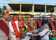 Kenakan Pakaian Adat, Kapolres bersama Pj Bupati Tapteng Bagikan 1.000 Bemdera dan Stiker